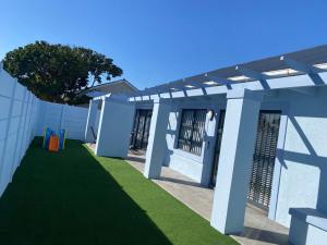 a pergola on a building with a green lawn at 32 On Gill Road Self Catering in Cape Town