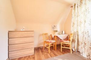a room with a table and two chairs and a desk at Apartamenty nad Młynówką in Chochołów