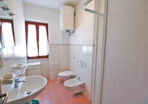 a white bathroom with a toilet and a sink at Orizzonti in Marina di Campo +61 photos