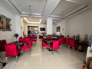 a dining room with tables and red chairs at A25 Hotel - 255 Lê Thánh Tôn in Ho Chi Minh City