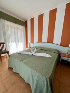 a bedroom with a bed with two towels on it at Hotel Soleado in Taormina