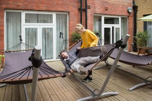 a man laying in a hammock on a deck at Wombat's City Hostel London in London