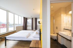 a bedroom with a bed and a sink and a toilet at Wombat's City Hostel London in London