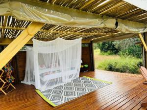 a pergola with a white canopy on a deck at Hluhluwe Bush Camp Glamping Village in Hluhluwe