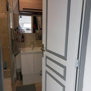 una puerta que conduce a un baño con lavabo y encimera en Cocooning, en La Londe-les-Maures