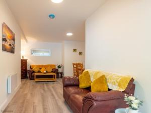 ein Wohnzimmer mit einem braunen Sofa und gelben Kissen in der Unterkunft Kings apartment 2 391 in Gowlaun