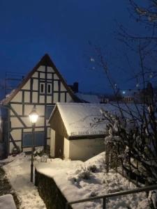 a snow covered building with a light in front of it at Ferienhaus Schotten in Schotten
