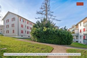 a building with a large bush next to a building at Dohlenweg 2 in Zürich