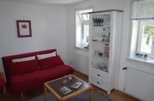 un soggiorno con divano rosso e tavolo di Ferienhaus Schotten a Schotten