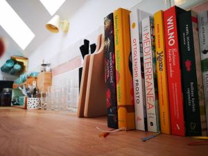una fila de libros sentados en un estante en Sezonowa. Noclegi i chleb, en Kłopotnica