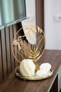 a plate with flowers on a table with a mirror at Prego Lux in Ulcinj