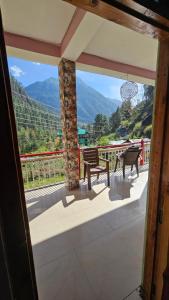 einen Blick vom Balkon eines Hauses mit Tischen und Stühlen in der Unterkunft Formosa Hostel & Cafe in Kasol