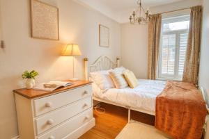 a bedroom with a bed with a dresser and a window at Cosy 3-Bed Home in Lincoln by Renzo, Close to Lincoln Hospital, Free Wi-Fi! in Lincolnshire