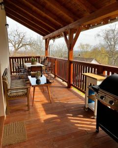 a wooden deck with a table and chairs on it at U nás ve lhotě - apartmány / celá chalupa in Borotín