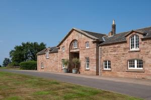 an old brick building with a road in front of it at Laurel Cottage in Cockburnspath