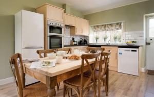 a kitchen with a wooden table and chairs at Laurel Cottage in Cockburnspath