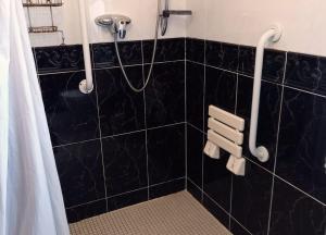 Łazienka z prysznicem wyłożona jest czarnymi kafelkami. w obiekcie M038 Accony, Louisburgh w mieście Louisburgh