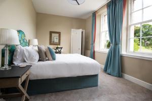 ein Schlafzimmer mit einem Bett, einem Schreibtisch und Fenstern in der Unterkunft Laurel Cottage in Cockburnspath