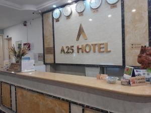 een Aziatisch hotelbord met klokken aan de muur bij A25 Hotel - 35 Mạc Thị Bưởi in Ho Chi Minh-stad