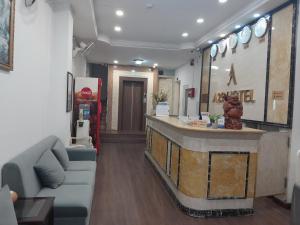 een lobby met een bar en een bank in een kamer bij A25 Hotel - 35 Mạc Thị Bưởi in Ho Chi Minh-stad