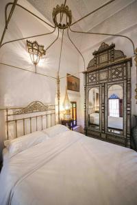 ein Schlafzimmer mit einem großen Bett und einem Spiegel in der Unterkunft Dar Dalila Fes in Fès