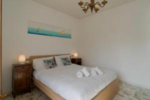 um quarto com uma cama branca e toalhas em Casa Silvia - Central - Terrace - WiFi em Bordighera