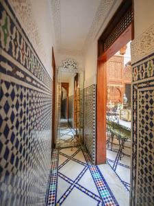 a hallway with a mirror and a wall with tiles at Dar Dalila Fes in Fez