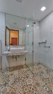 a bathroom with a sink and a glass shower at Elphinstone Hotel in Mumbai