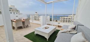 ein Wohnzimmer mit einem Sofa und einem Tisch auf dem Balkon in der Unterkunft Luxury penthouse in Sousse in Sousse