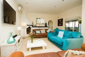 un soggiorno con divano blu e camino di Villa Lucy - By AZ Rentals a Puerto del Carmen