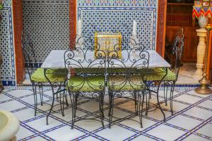 a dining room table with four chairs and a candle at Dar Dalila Fes in Fez +133 photos
