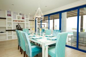 una sala da pranzo con tavolo bianco e sedie blu di Villa Lucy - By AZ Rentals a Puerto del Carmen