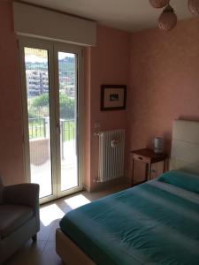 Schlafzimmer mit einem Bett und einer Glasschiebetür in der Unterkunft Appartamento 500 metri dal mare in Tortoreto Lido