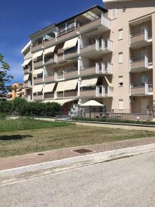 ein großes Apartmenthaus mit Rasen davor in der Unterkunft Appartamento 500 metri dal mare in Tortoreto Lido