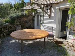 einen Holztisch und zwei Stühle vor einem Gebäude in der Unterkunft Appartement dans résidence calme dans les Monts du Lyonnais in Soucieu-en-Jarrest