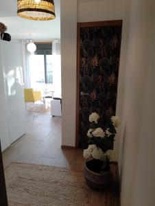 un pasillo con una puerta con un jarrón de flores en Ático VistasMar (Castiñeiras-Ribeira), en Ribeira