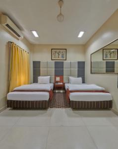 um quarto com duas camas num quarto em Elphinstone Hotel em Mumbai