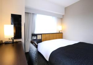 Postel nebo postele na pokoji v ubytování APA Hotel Ueno Ekikita