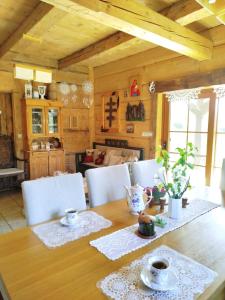 une salle à manger avec une table en bois et des chaises blanches dans l'établissement Miejsce po Dworze, à Polana