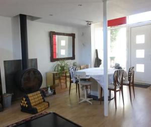 ein Wohnzimmer mit einem weißen Tisch und Stühlen in der Unterkunft Le Jardin Ecolodge in Lamarque-Pontacq