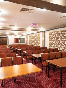 uma sala de conferências vazia com mesas e cadeiras em Hotel Alma-Ata em Borovoe