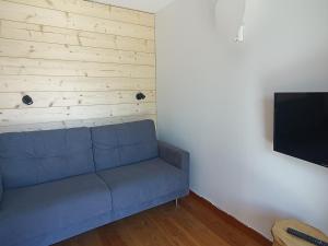 Il comprend un salon doté d'un canapé bleu et d'une télévision à écran plat. dans l'établissement Studio Montgenèvre, 1 pièce, 4 personnes - FR-1-445-204, à Montgenèvre