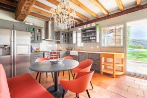 a kitchen with a table and orange chairs at MAISON BASQUE D'EXCEPTION - SARE in Sare