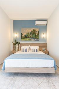 een slaapkamer met een groot bed met blauwe muren bij Amazing View Villa Aliki with Infinity Pool & Spa in Lygaria