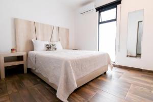 1 dormitorio con 1 cama grande y suelo de madera en Arkana 9 Suites Grupo Amber - Collection O en Playa del Carmen