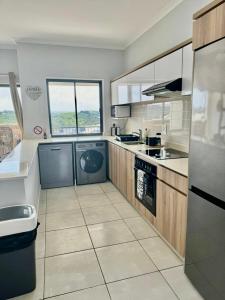 a large kitchen with white appliances and a large window at Ballito Hills 2 bedroom apartment 1272 in Ballito