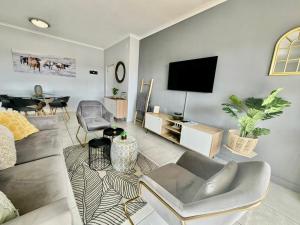 a living room with a couch and a flat screen tv at Ballito Hills 2 bedroom apartment 1272 in Ballito