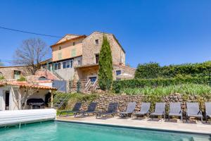 a villa with a swimming pool and chairs at Maison de village in La Tour-sur-Orb