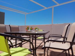 - une table et des chaises dans une pièce dotée de plafonds bleus dans l'établissement Atico Canet, à Canet d'En Berenguer