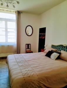 a bedroom with a large bed with a large window at Les MIRABELLES chambres d'hôtes in Sisteron